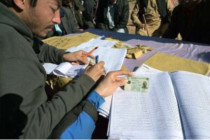 Polling agents searching the name of voter in the voter list outside polling station during General Election-2024