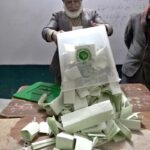 Election official opens ballot box to count votes after polls end during the Pakistan’s General Elections-2024