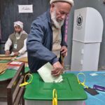 Polling agents searching the name of voter in the voter list outside polling station during General Election-2024