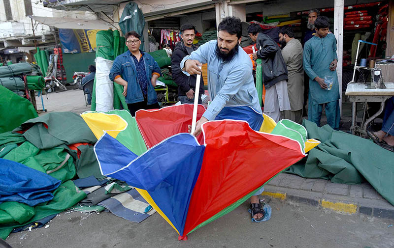 A vendor displaying colorful umbrella to attract customers at his workplace