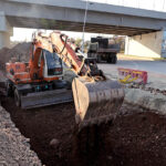 Labourer busy in construction work of Park Road with the help of heavy machinery during development work in the city