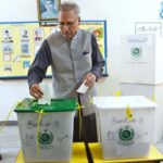 President Dr. Arif Alvi receiving ballot paper to cast his vote in the polling station during General Election-2024