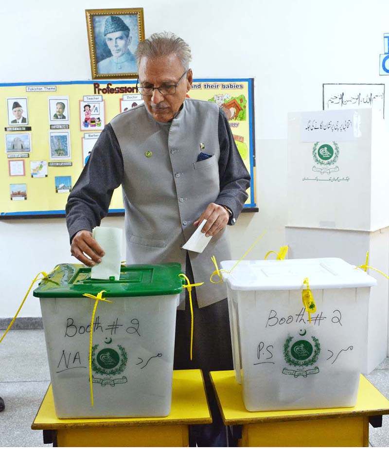 President Dr. Arif Alvi receiving ballot paper to cast his vote in the polling station during General Election-2024