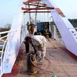 A welder finishing grills of a new pedestrian bridge over the Srinagar Highway in the Federal Capital