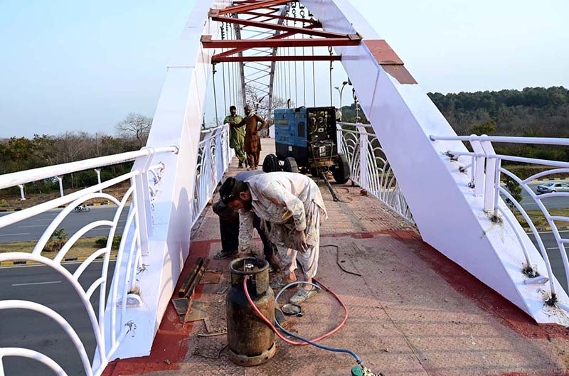 A welder finishing grills of a new pedestrian bridge over the Srinagar Highway in the Federal Capital
