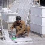 A worker is busy finishing the marble with the help of a machine at his workplace
