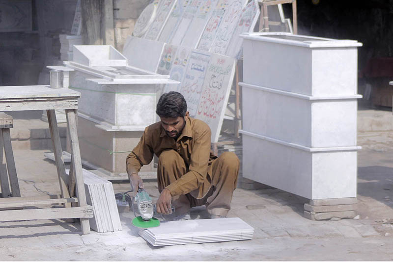 A worker is busy finishing the marble with the help of a machine at his workplace