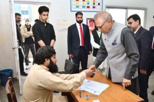 President Dr. Arif Alvi receiving ballot paper to cast his vote in the polling station during General Election-2024