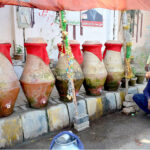 A person drink water from clay made cooler at jail road