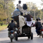A motorcyclist is pushing a machine used for construction