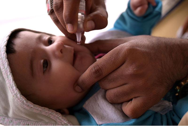 A health worker administering polio drops to child at Railway station during the start of Polio Campaign in the city