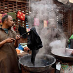 Workers busy in dyeing (coloring) women clothes at their workplace at Kashmir Bazar