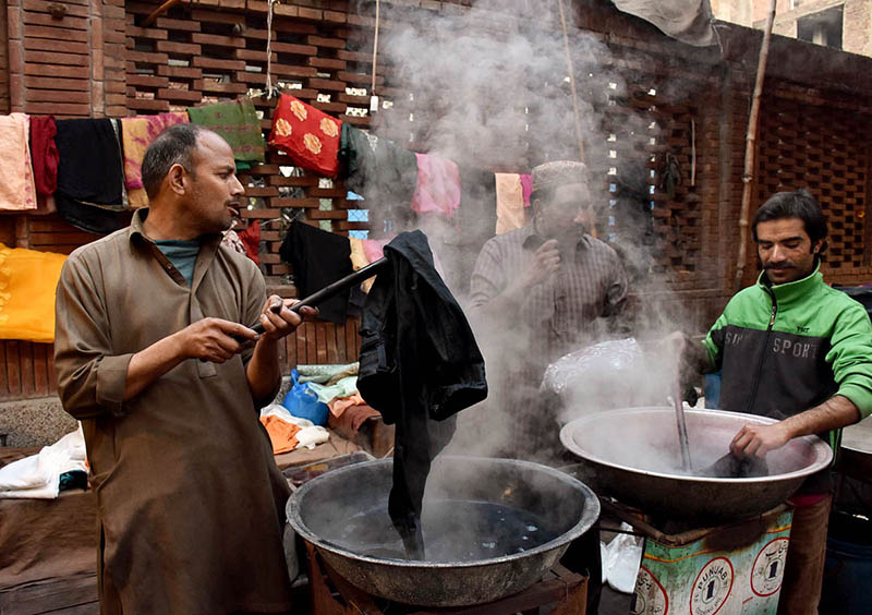 Workers busy in dyeing (coloring) women clothes at their workplace at Kashmir Bazar