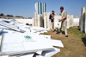Workers of the Election Commission Office sorting ballot boxes to be sent to polling stations for the upcoming General Elections-2024 at Qayyum Sports Complex.