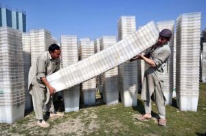 Workers of the Election Commission Office sorting ballot boxes to be sent to polling stations for the upcoming General Elections-2024 at Qayyum Sports Complex.