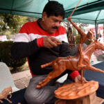 A craftsman is making a horse model by hand on the occasion of Winter Festival at Al Hamra Cultural Complex
