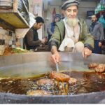 An elderly person busy in making traditional “Chapli Kabab” for customers at Fawara Chowk.