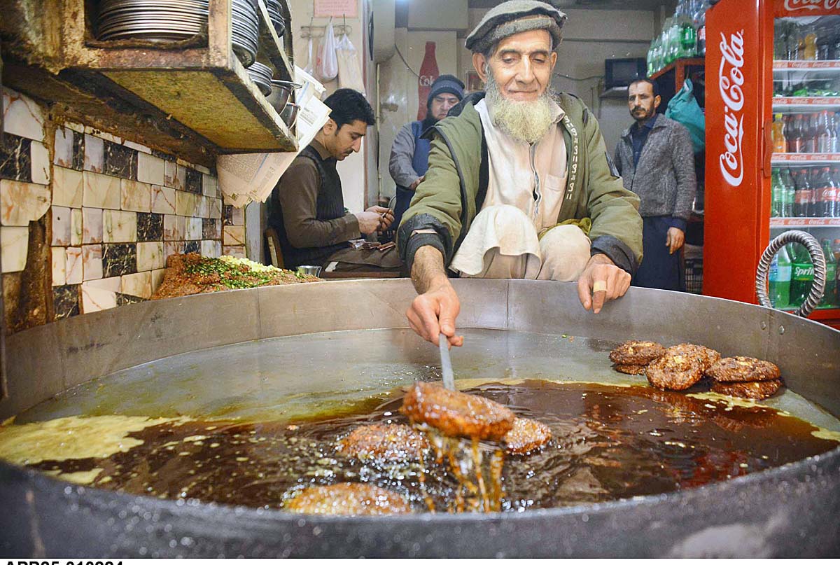 An elderly person busy in making traditional “Chapli Kabab” for customers at Fawara Chowk.