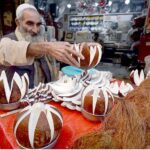 An aged man displaying coconuts to attract the customer at Sadar Road