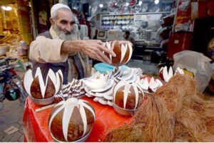 An aged man displaying coconuts to attract the customer at Sadar Road