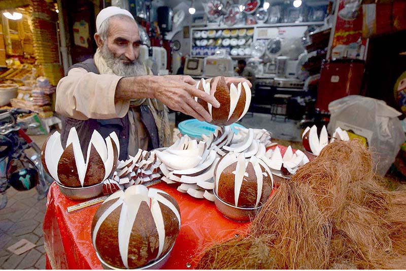 An aged man displaying coconuts to attract the customer at Sadar Road