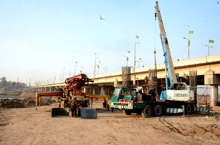 Heavy machinery being used to expand road during development work at Ravi bridge.