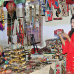 An artisan giving final touch to painting on a stall during last day of the Blue Fair organized by the Women Chamber of Commerce