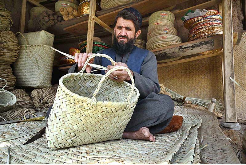 A craftsman busy in making a basket from dried date palm leaves at his shop in the Dabgari area