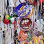 A vendor displaying colourful bangles and jewelry and items to attract the customers at his roadside setup near Shahi Bazar.