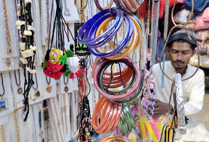 A vendor displaying colourful bangles and jewelry and items to attract the customers at his roadside setup near Shahi Bazar.