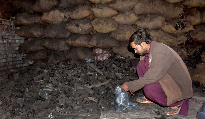 A vendor selling coal sacks as per increased demand in winter season