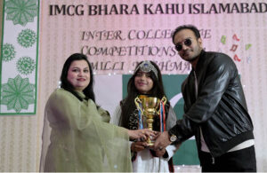 Principal, Miss. Najam UN Nisa giving winning trophy to the student during inter collegiate Competition of milli naghma 2024 at IMCG Bhara Kahu