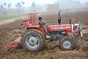 A young farmer ploughing field with the help of tractor