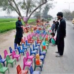 A vendor selling small plastic chairs at roadside