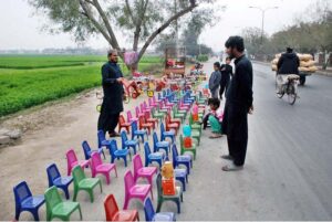 A vendor selling small plastic chairs at roadside