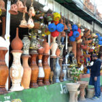 A shopkeeper is attracting customers with decorative items made of clay