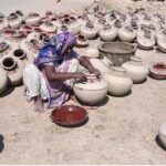 A worker woman paints clay-made pitcher at her work place near Jamshoro Road.
