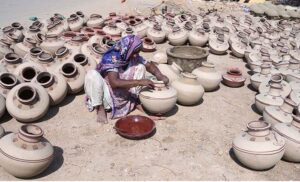  A worker woman paints clay-made pitcher at her work place near Jamshoro Road. 