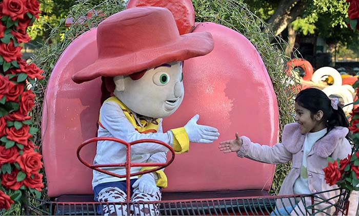 A girl shakes hand with a statue installed at Lake View Park in the federal capital.