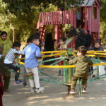 Children enjoy swings at Local Park in the city