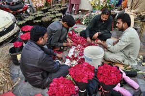 People selecting and purchasing the fresh flowers and flower bouquet at a roadside stall ahead of Valentine's Day at local market in the Provincial Capital
