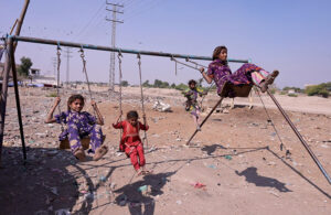 Gypsy girls enjoy swing at site area