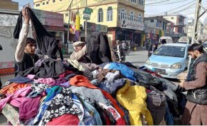 People busy in selecting and purchasing second hand jackets from the roadside vendor