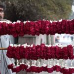 A vendor waiting the customers for selling the flowers hands and neck garlands on the roadside in the Provincial Capital