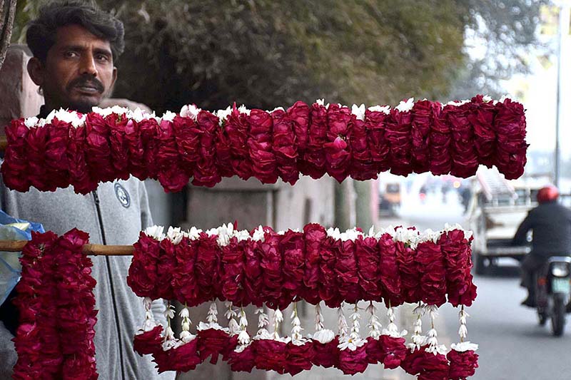 A vendor waiting the customers for selling the flowers hands and neck garlands on the roadside in the Provincial Capital