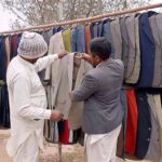 A customer buying coat from roadside vendor