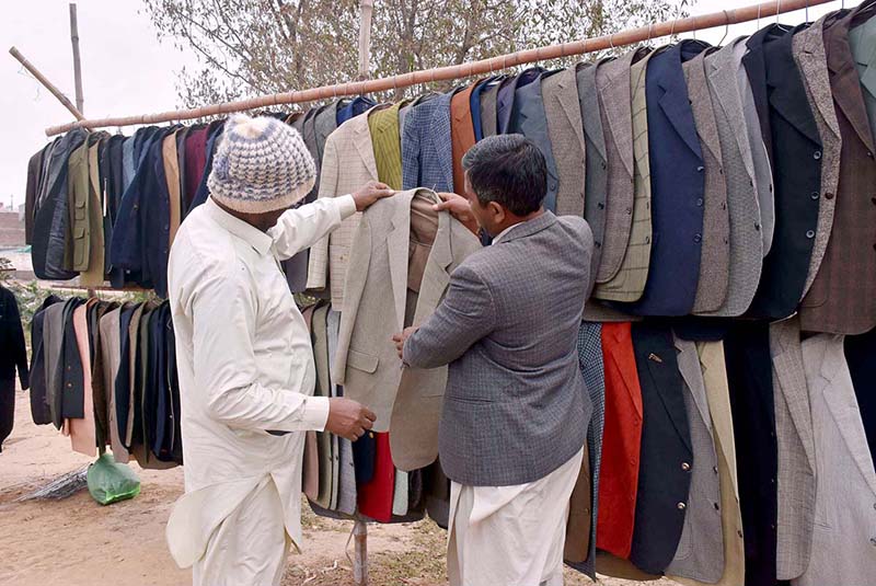 A customer buying coat from roadside vendor