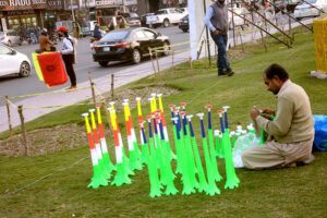 A vendor displayed horns while a youngster selling PSL flags at a roadside as PSL Cricket matches commence tonight