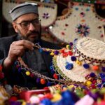 An artisan giving the final touch to a traditional cap at his workplace