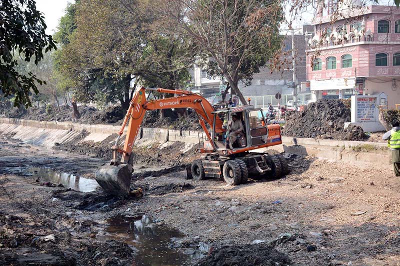 Irrigation department worker cleaning aRakh Branch canal with the help of caterpillar during canal cleaning campaign